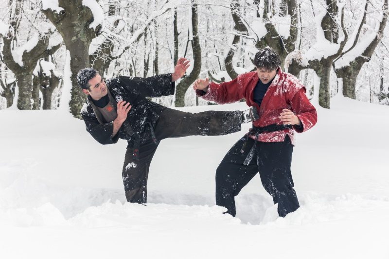 Patada de sambo sobre la nieve con la kurtka roja